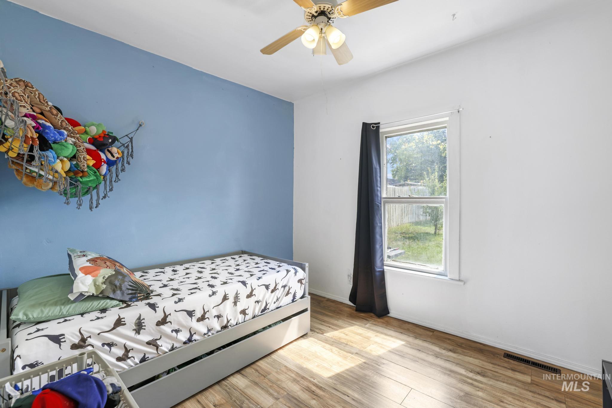 Bedroom featuring wood finished floors and a ceiling fan