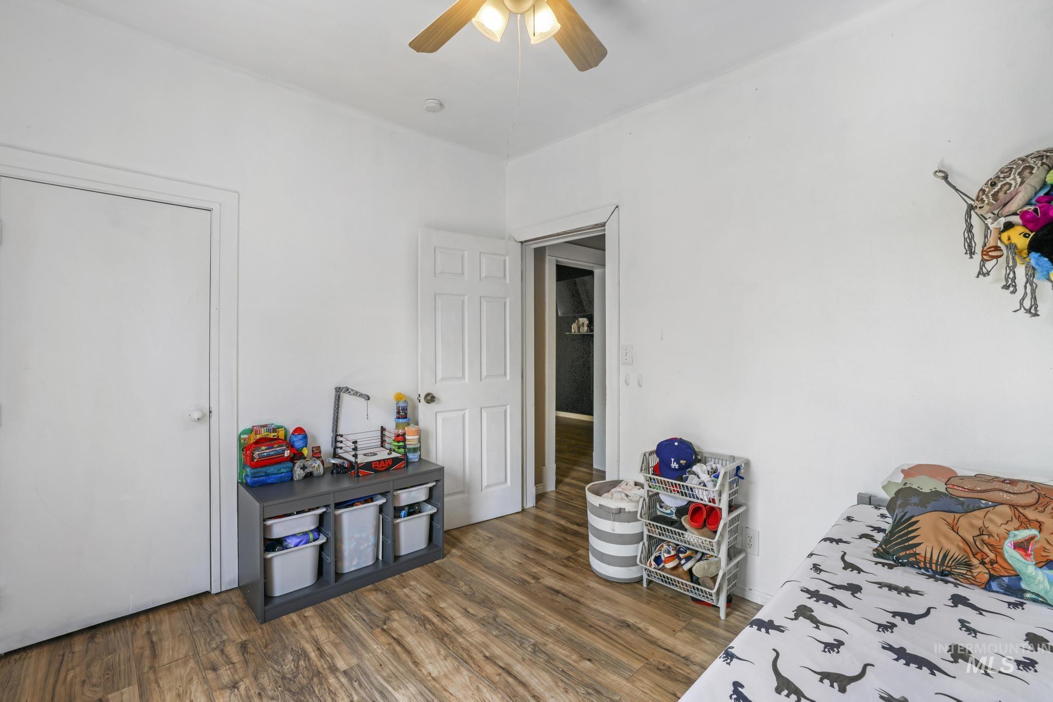 Bedroom featuring dark wood-style flooring and ceiling fan