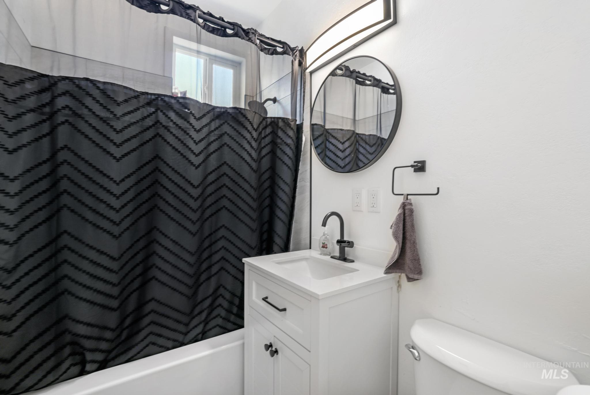 Bathroom with vanity and shower / tub combo