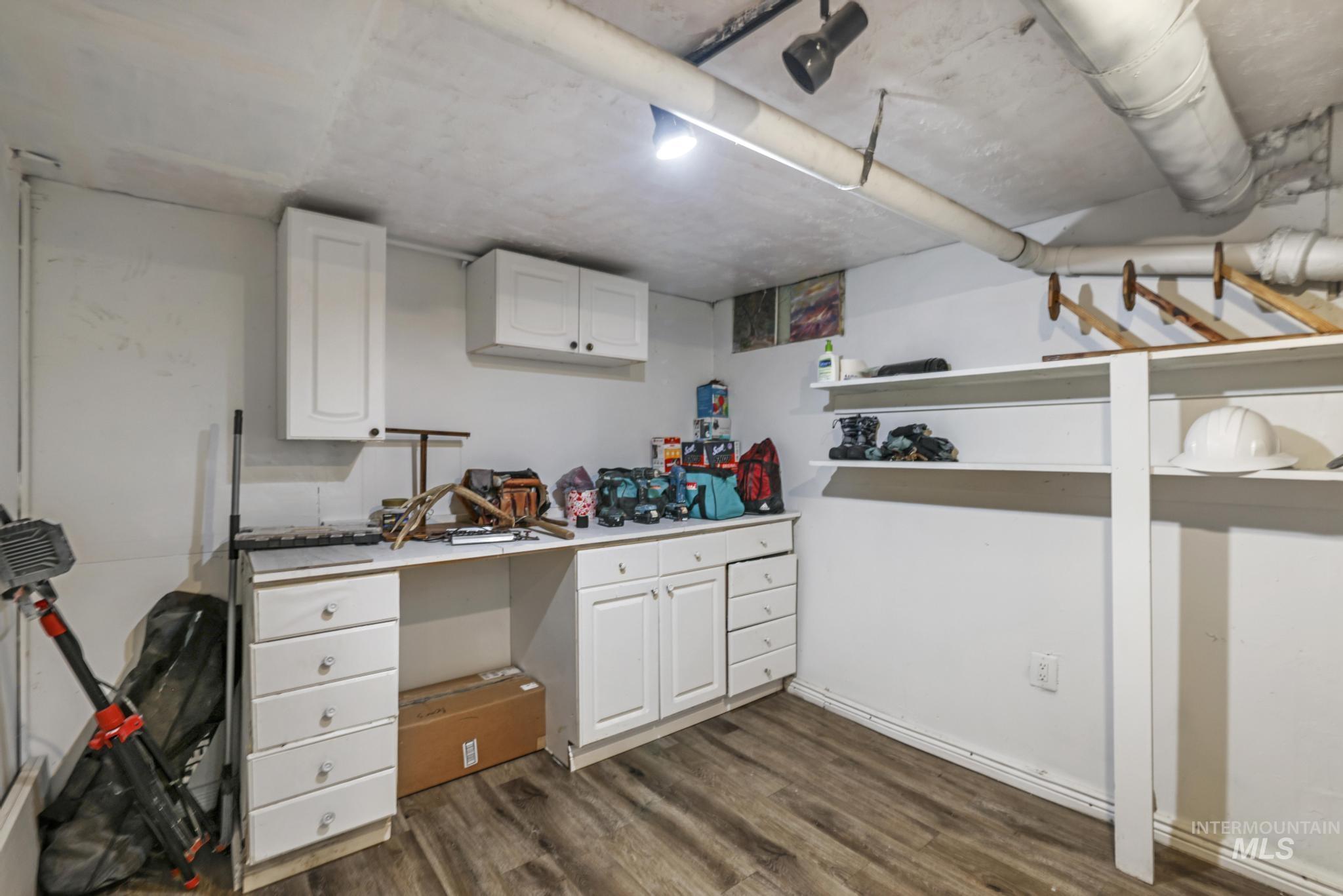 Finished below grade area with dark wood-style floors and baseboards