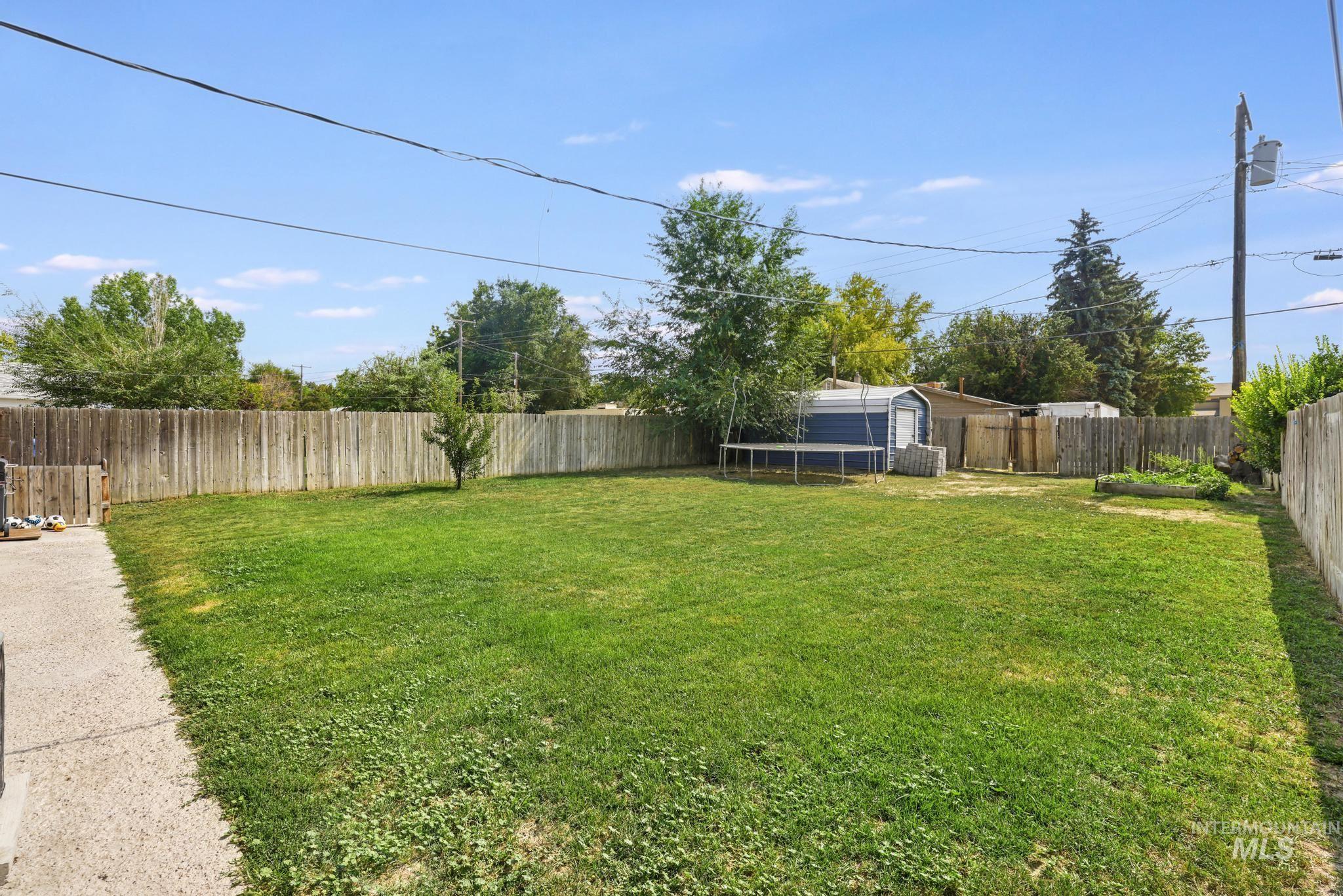Fenced backyard with a trampoline