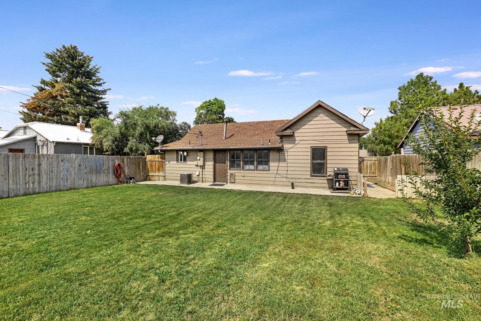 Back of house with a fenced backyard, a patio, and roof with shingles