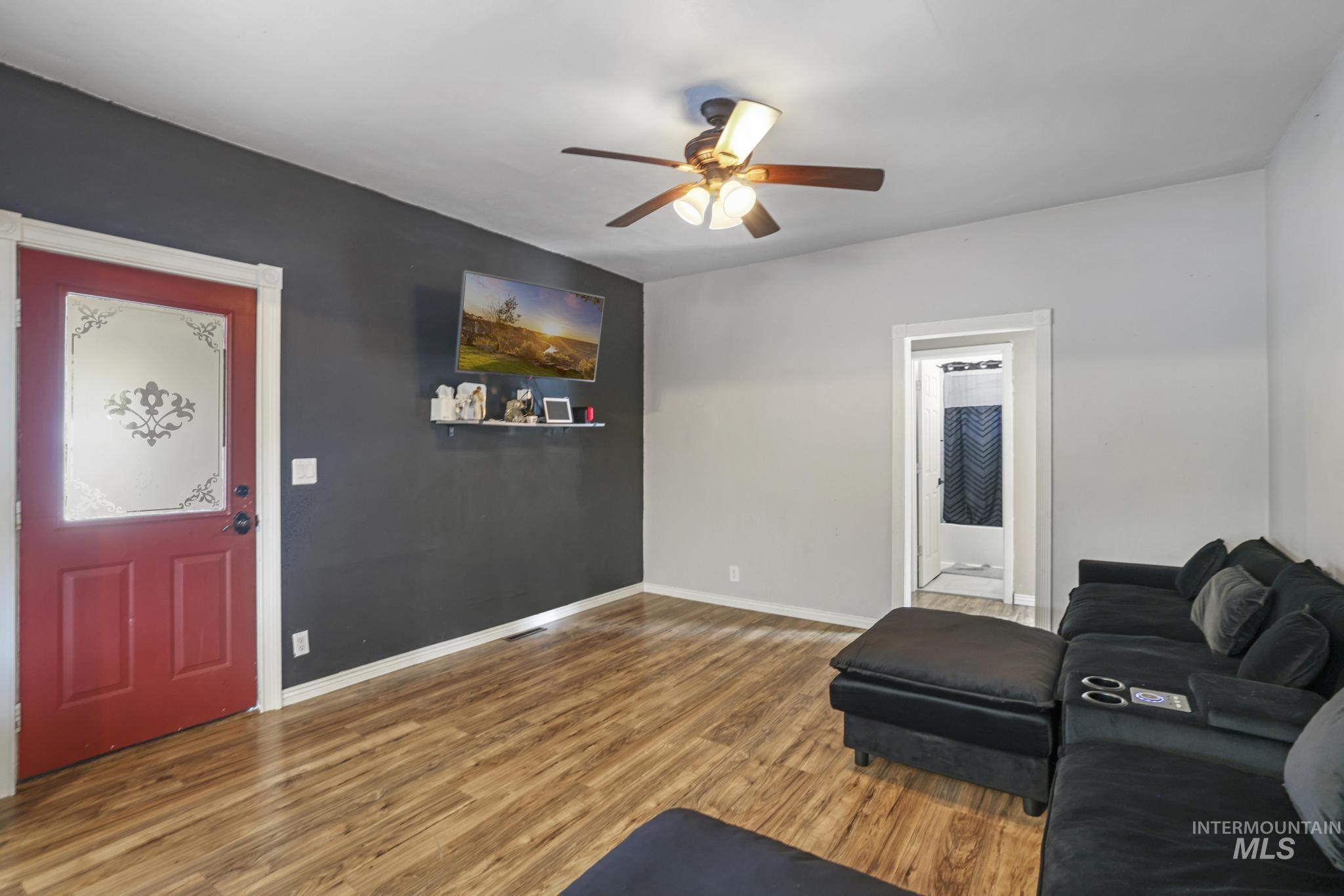 Living area with wood finished floors and a ceiling fan