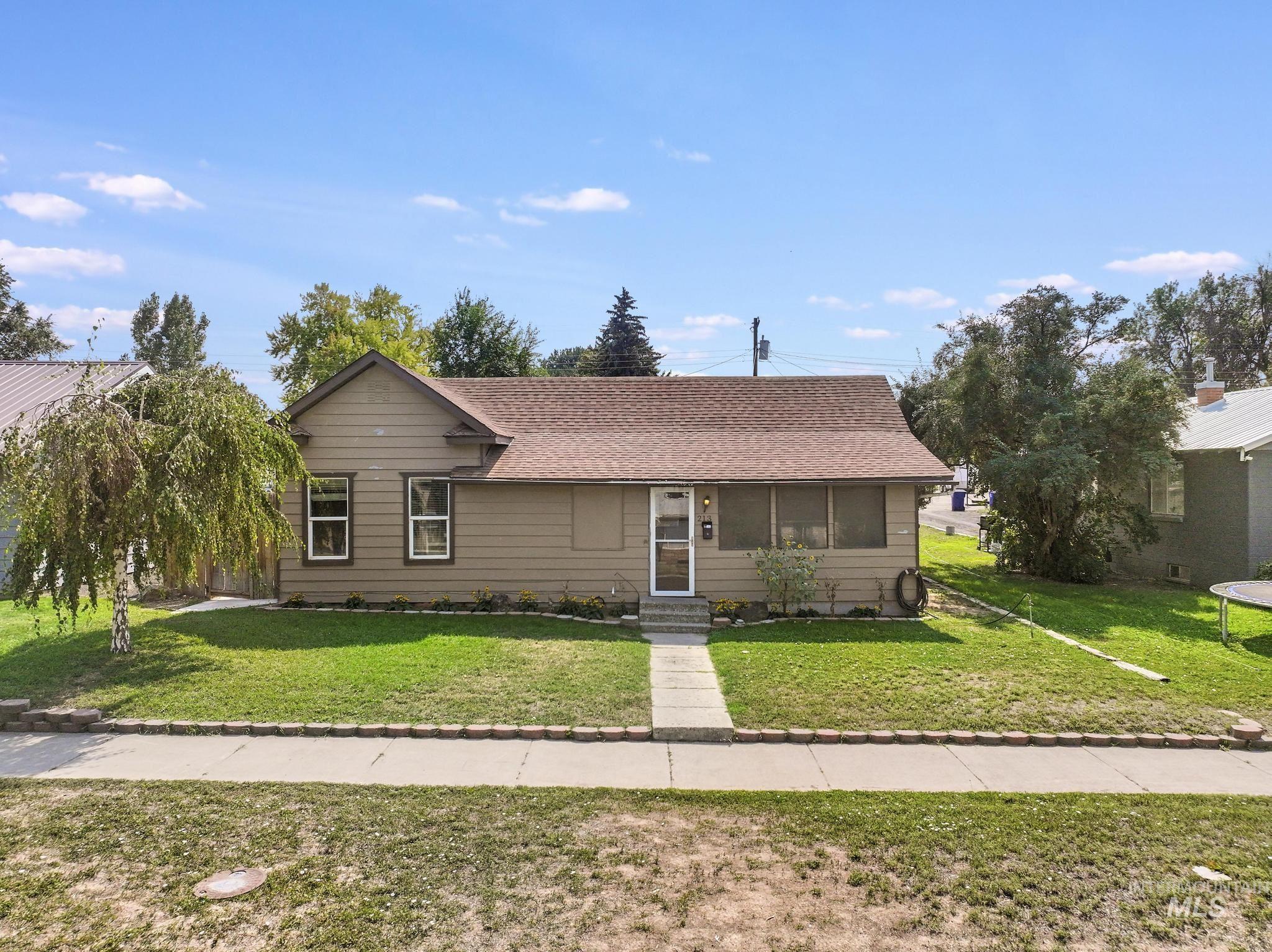 View of front of home with roof with shingles and a front lawn