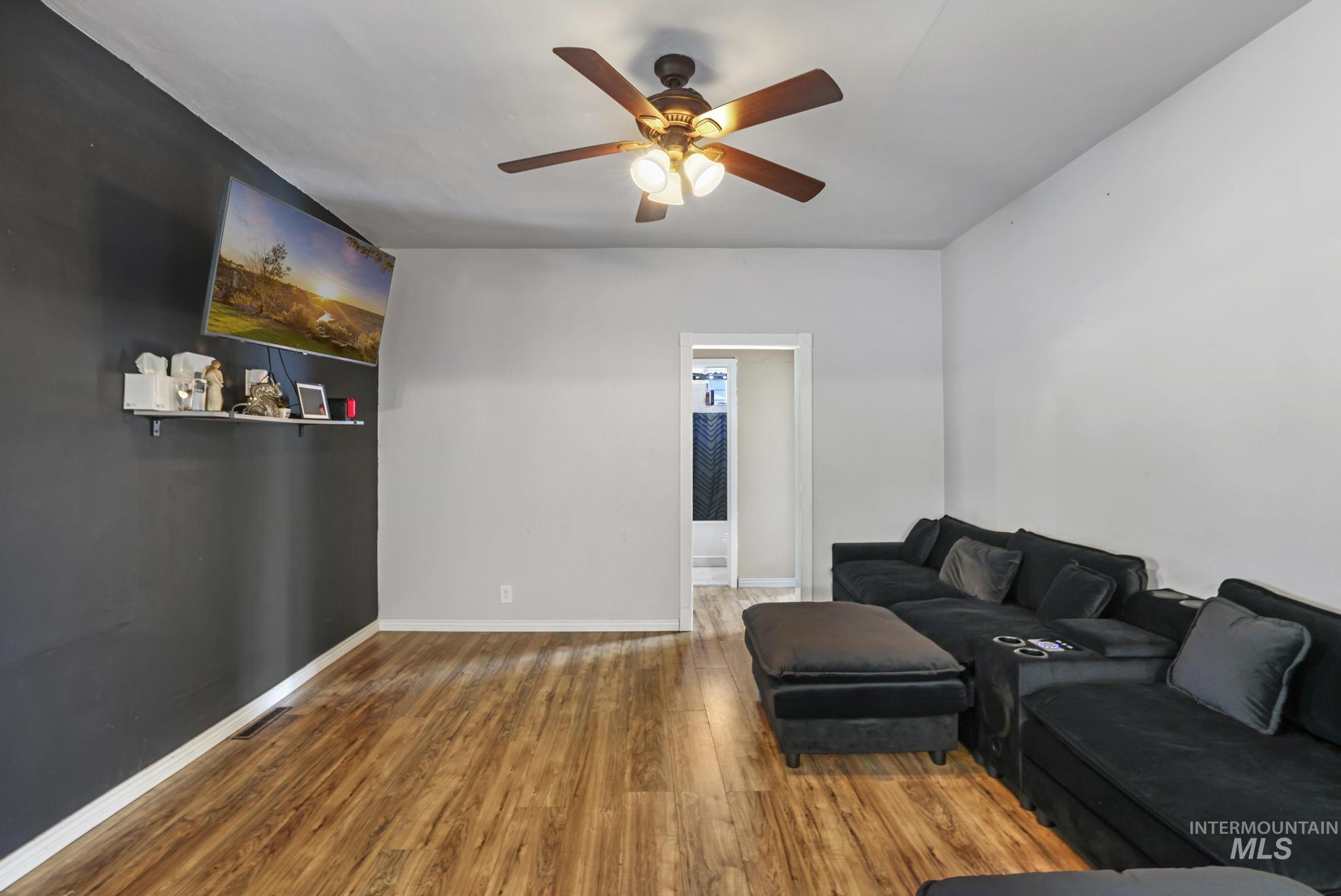 Living room featuring wood finished floors and a ceiling fan
