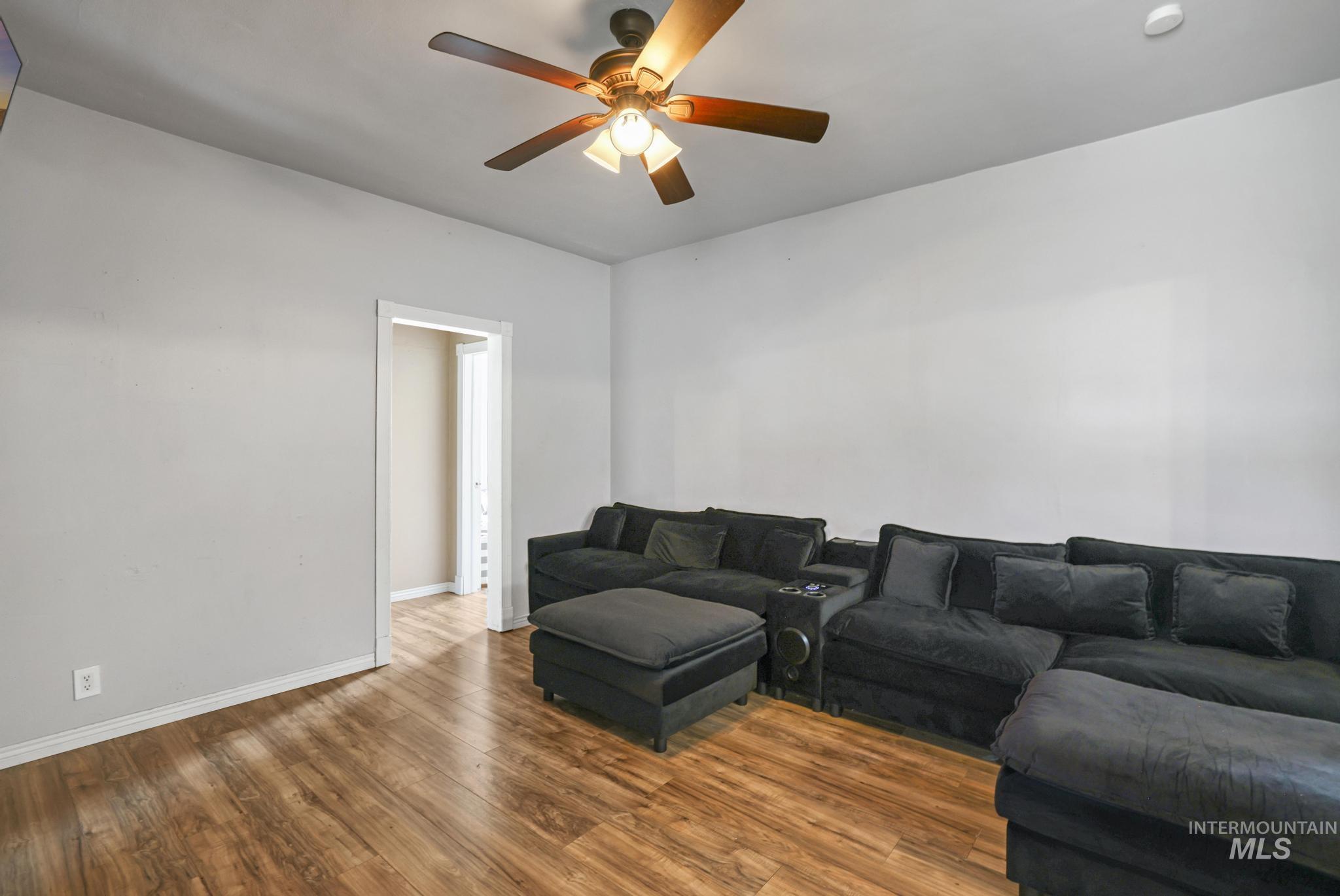 Living area with wood finished floors and ceiling fan