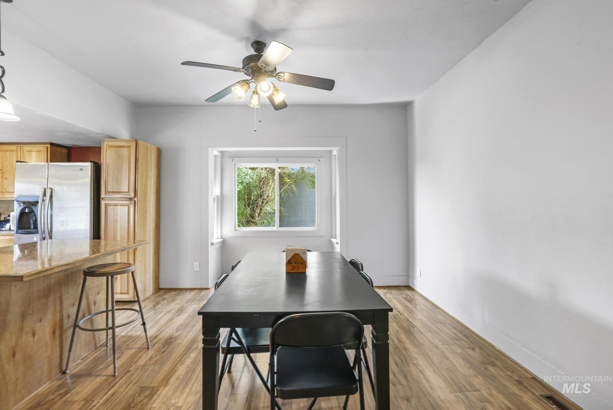 Dining room with light wood finished floors and ceiling fan