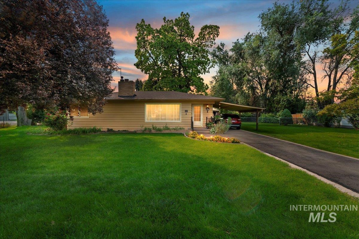 Ranch-style home with driveway, a carport, and a chimney