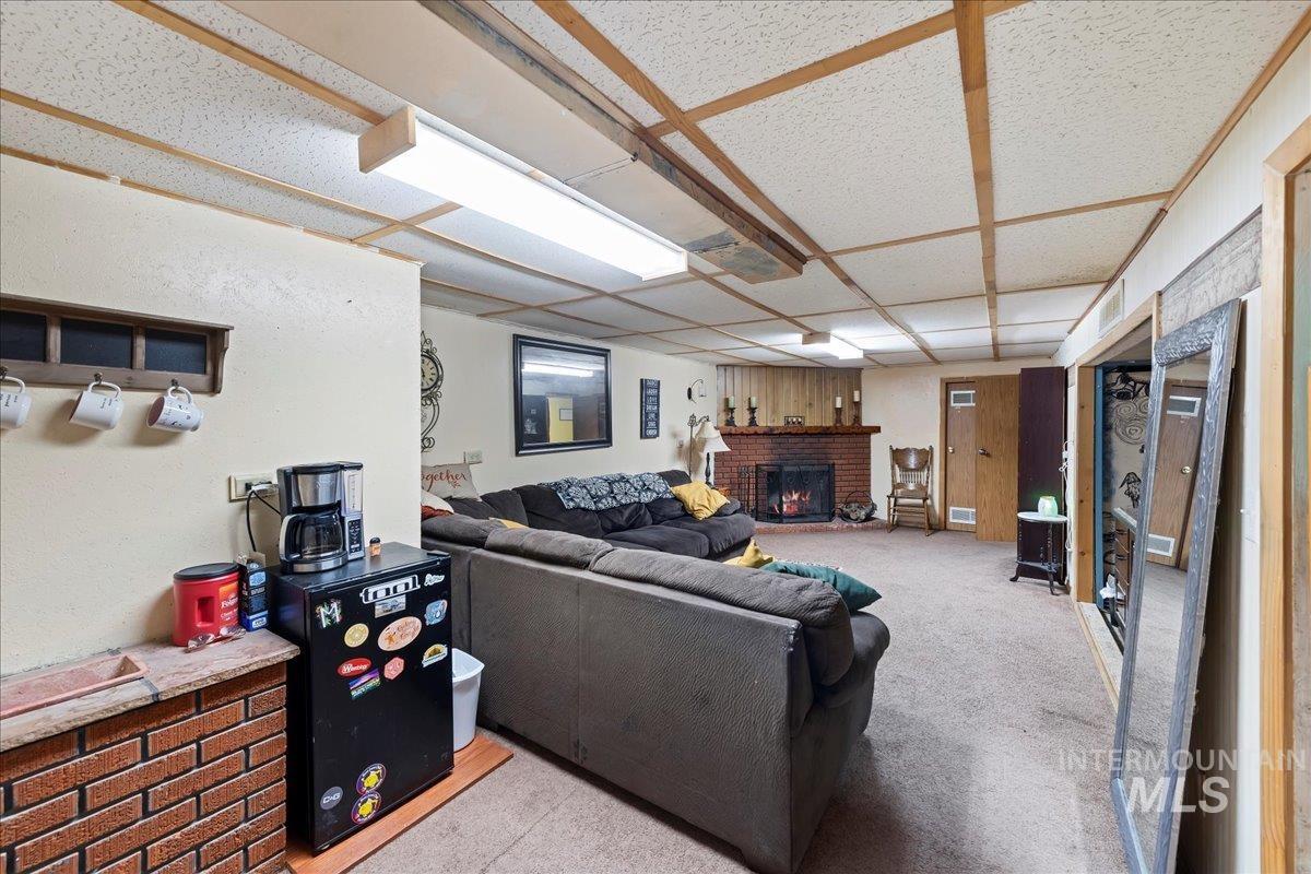 Living area featuring light carpet and a fireplace