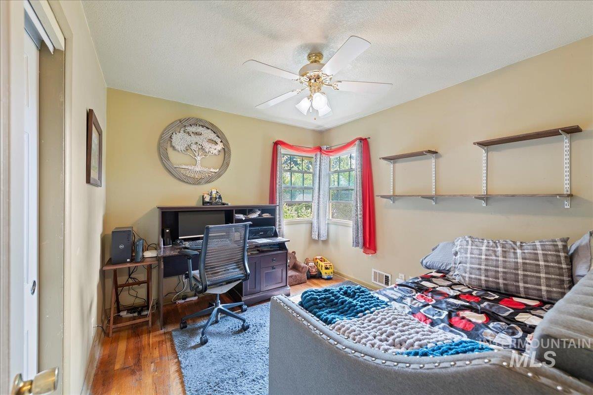 Office space featuring wood finished floors, a textured ceiling, and a ceiling fan