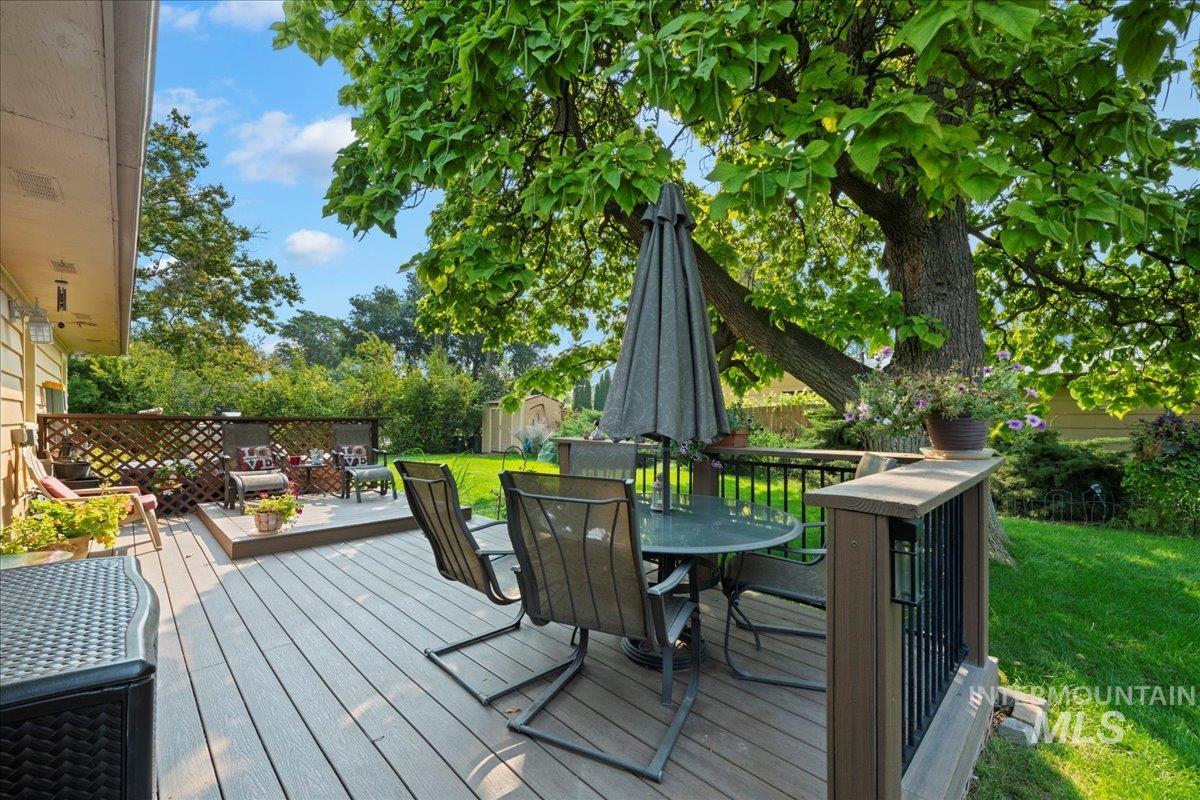 Deck featuring outdoor dining space, a storage unit, and a fenced backyard