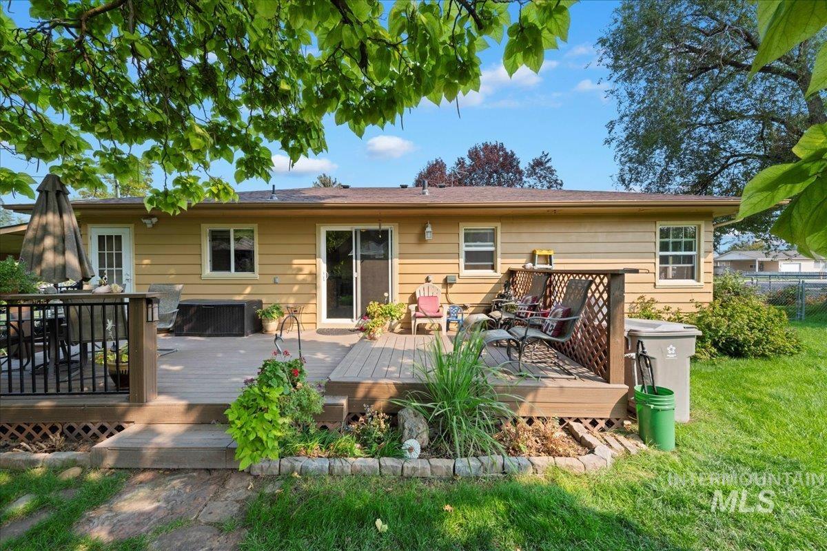 Rear view of property with a deck and a yard