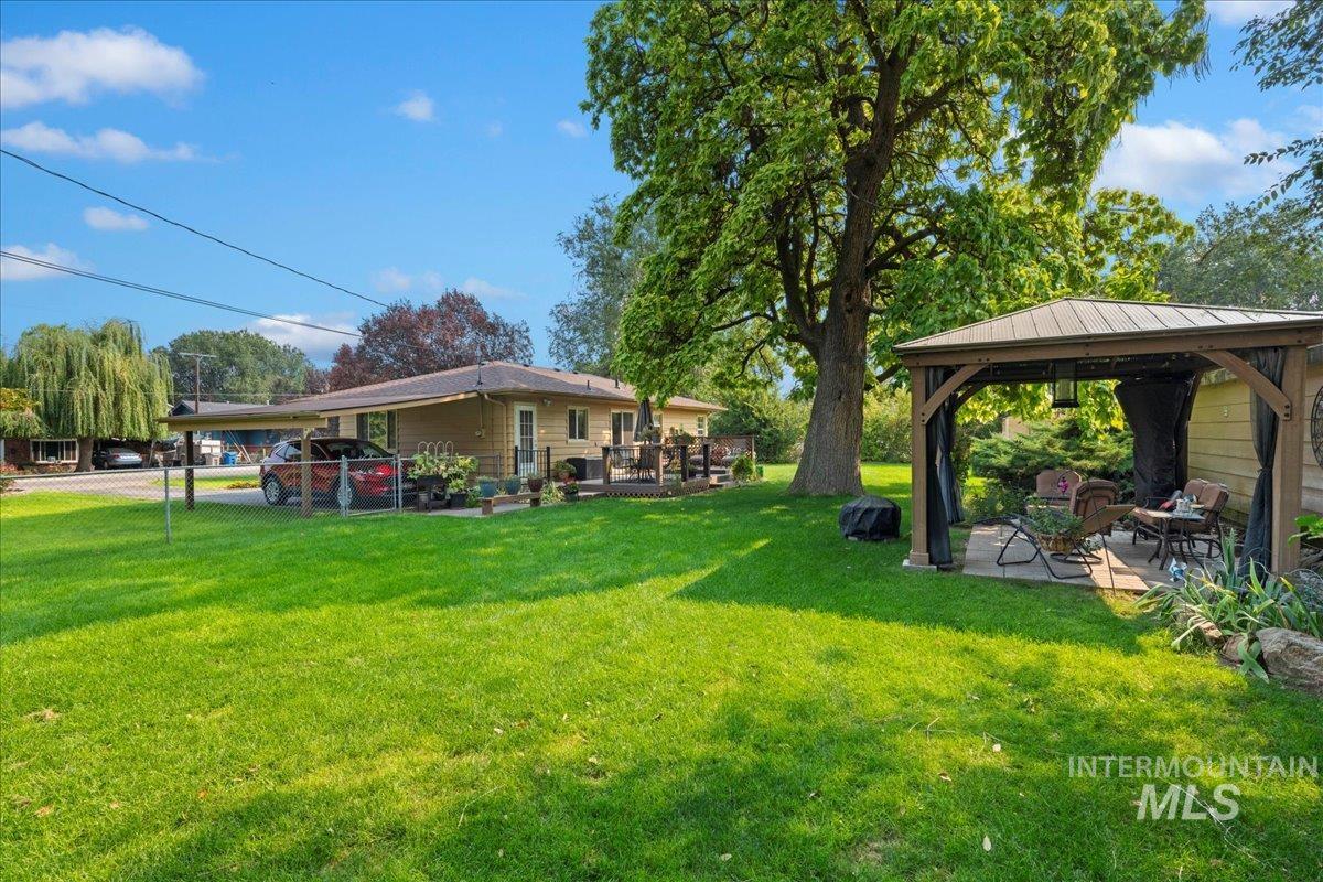 View of green lawn with a gazebo and a patio area