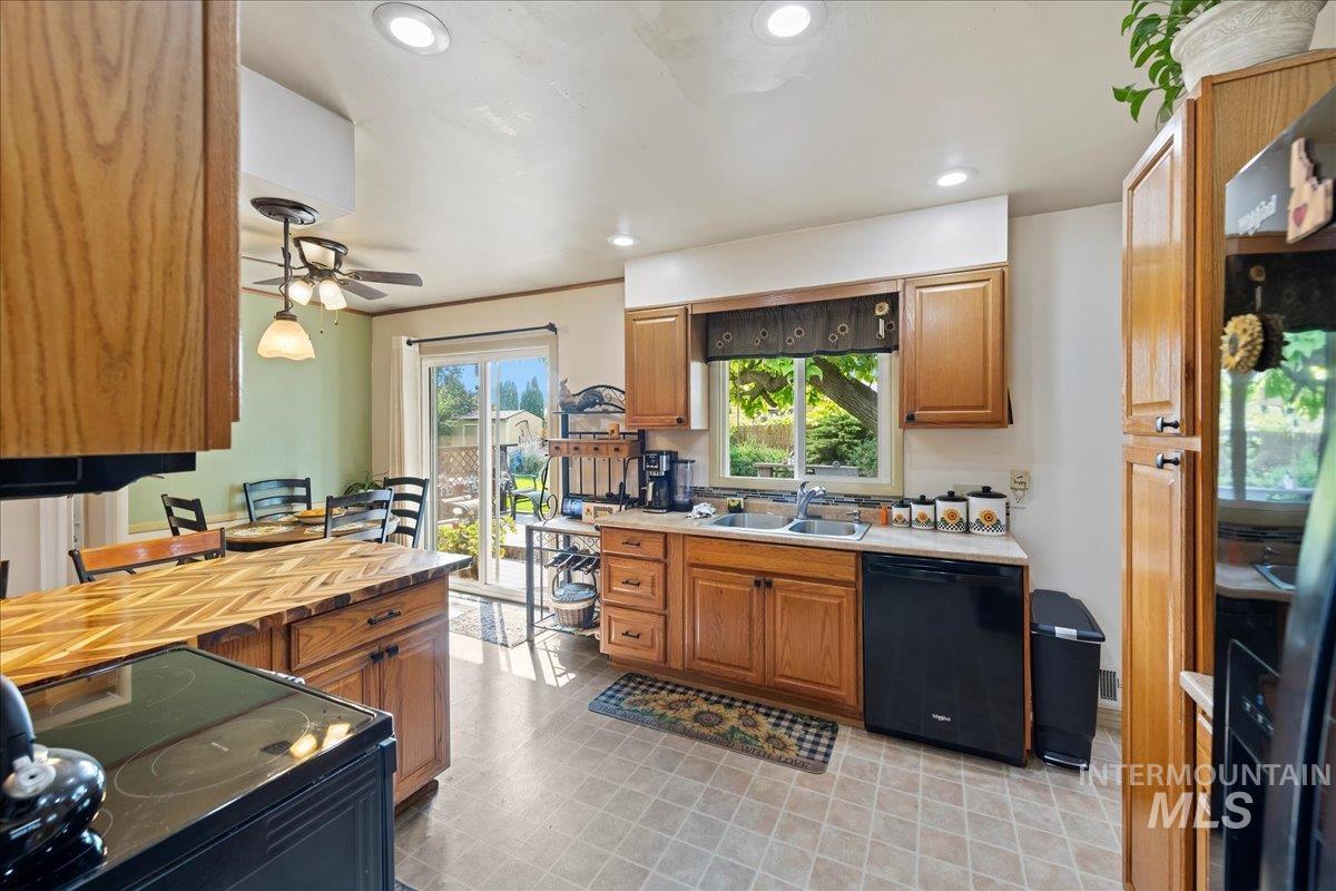 Kitchen with black appliances, recessed lighting, brown cabinets, and a ceiling fan