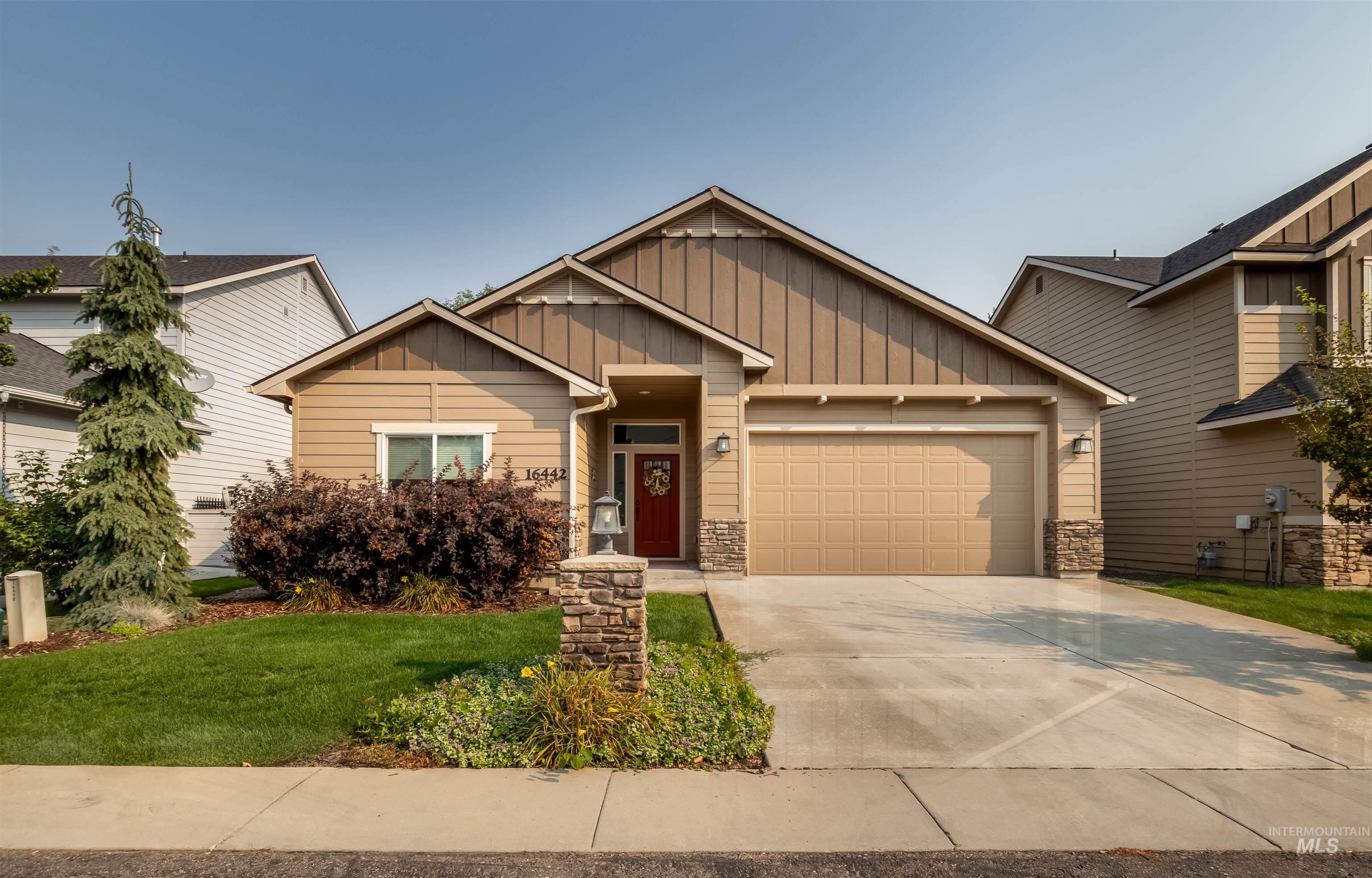 Craftsman house with stone siding, board and batten siding, concrete driveway, and a garage