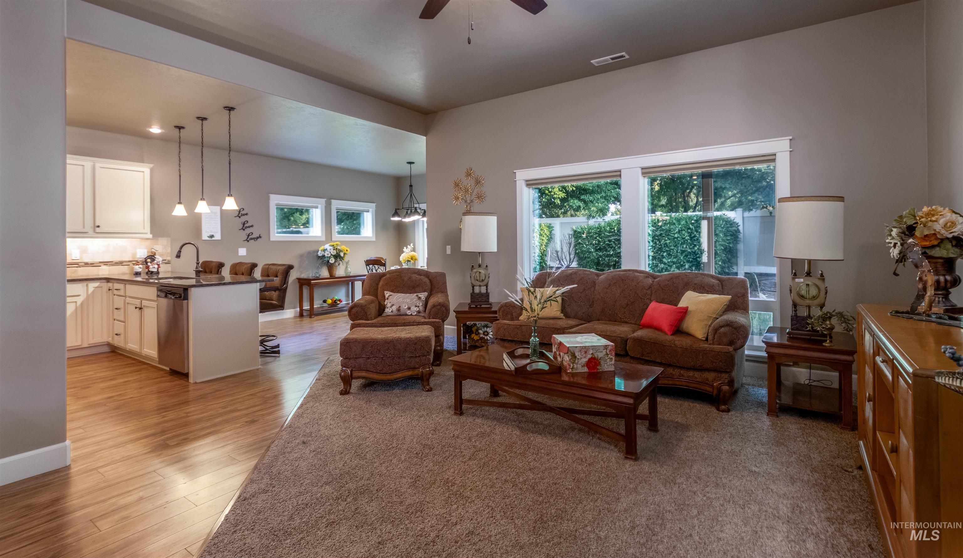 Living area with a ceiling fan and light wood-style floors