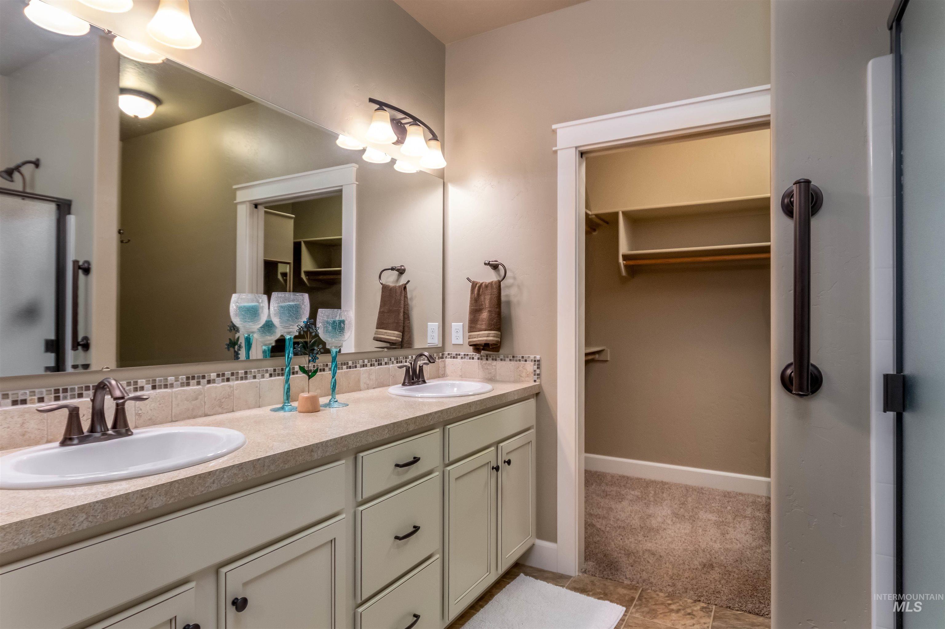 Bathroom with double vanity and a spacious closet