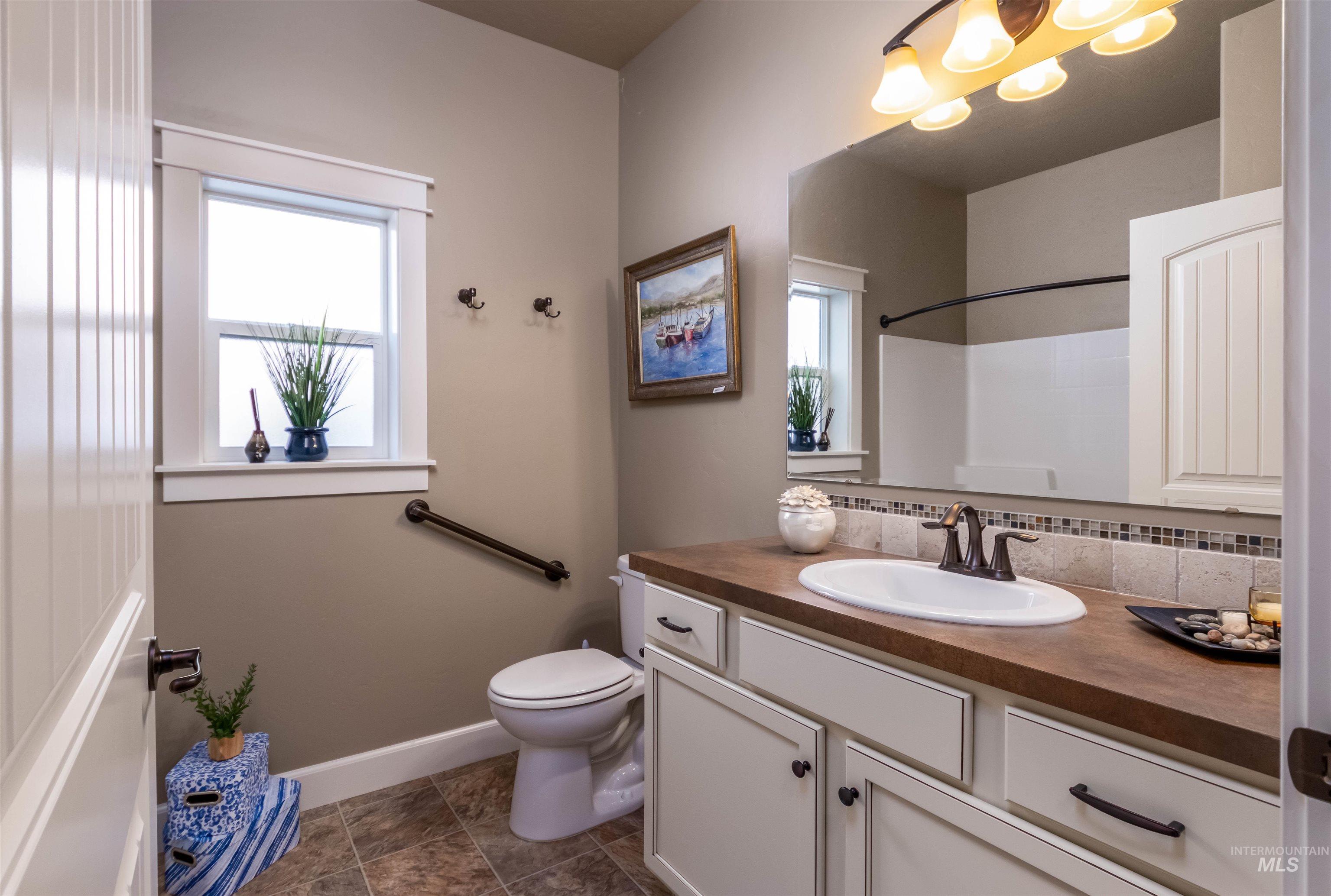 Full bath featuring vanity and backsplash