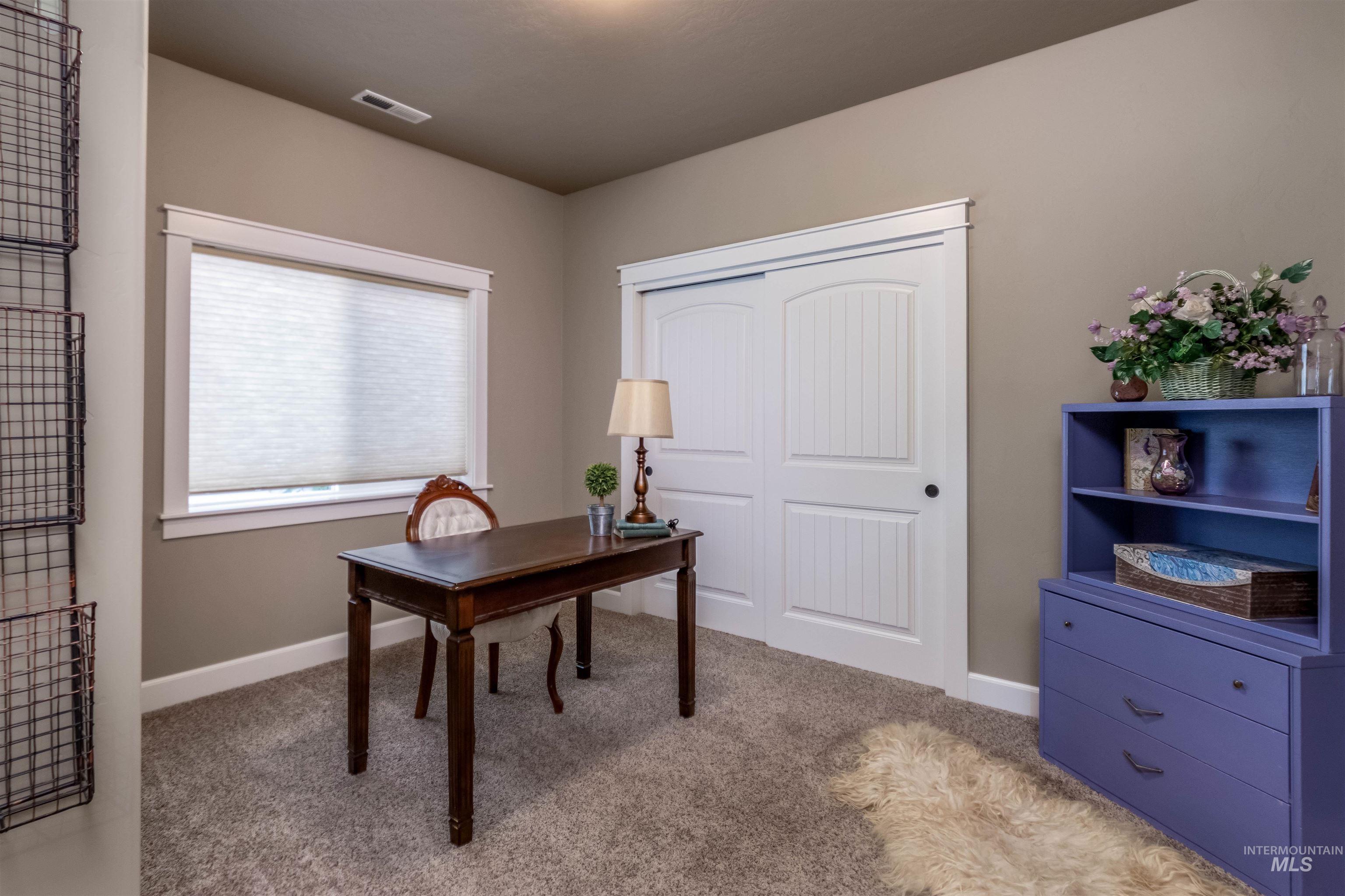 Office area featuring light carpet and baseboards