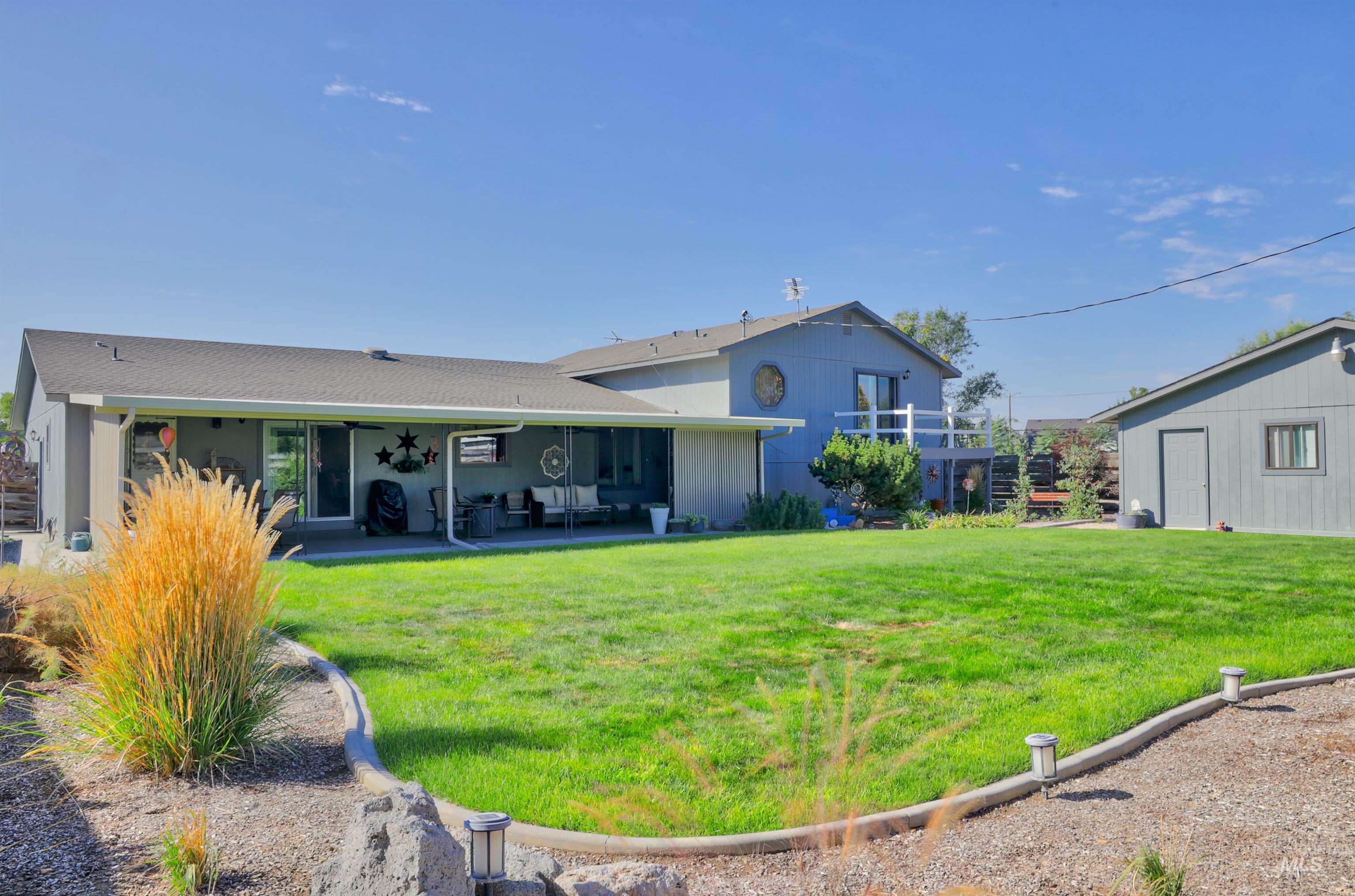 Back of property featuring a lawn and a patio