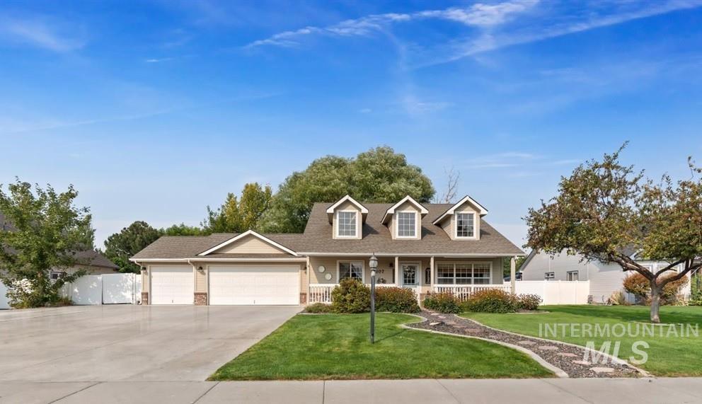 Cape cod house featuring covered porch, driveway, an attached garage, and brick siding