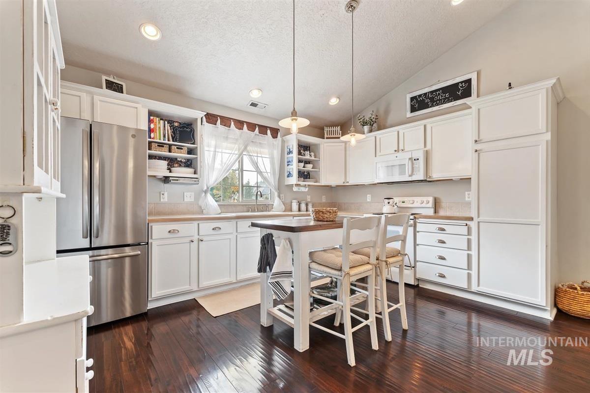 Kitchen featuring hanging light fixtures, open shelves, white appliances, white cabinetry, and recessed lighting