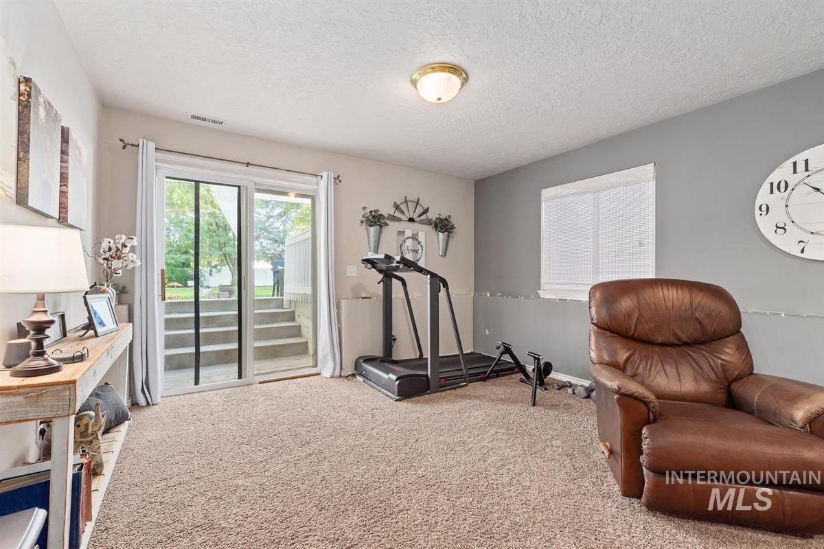 Workout room featuring a textured ceiling and carpet flooring
