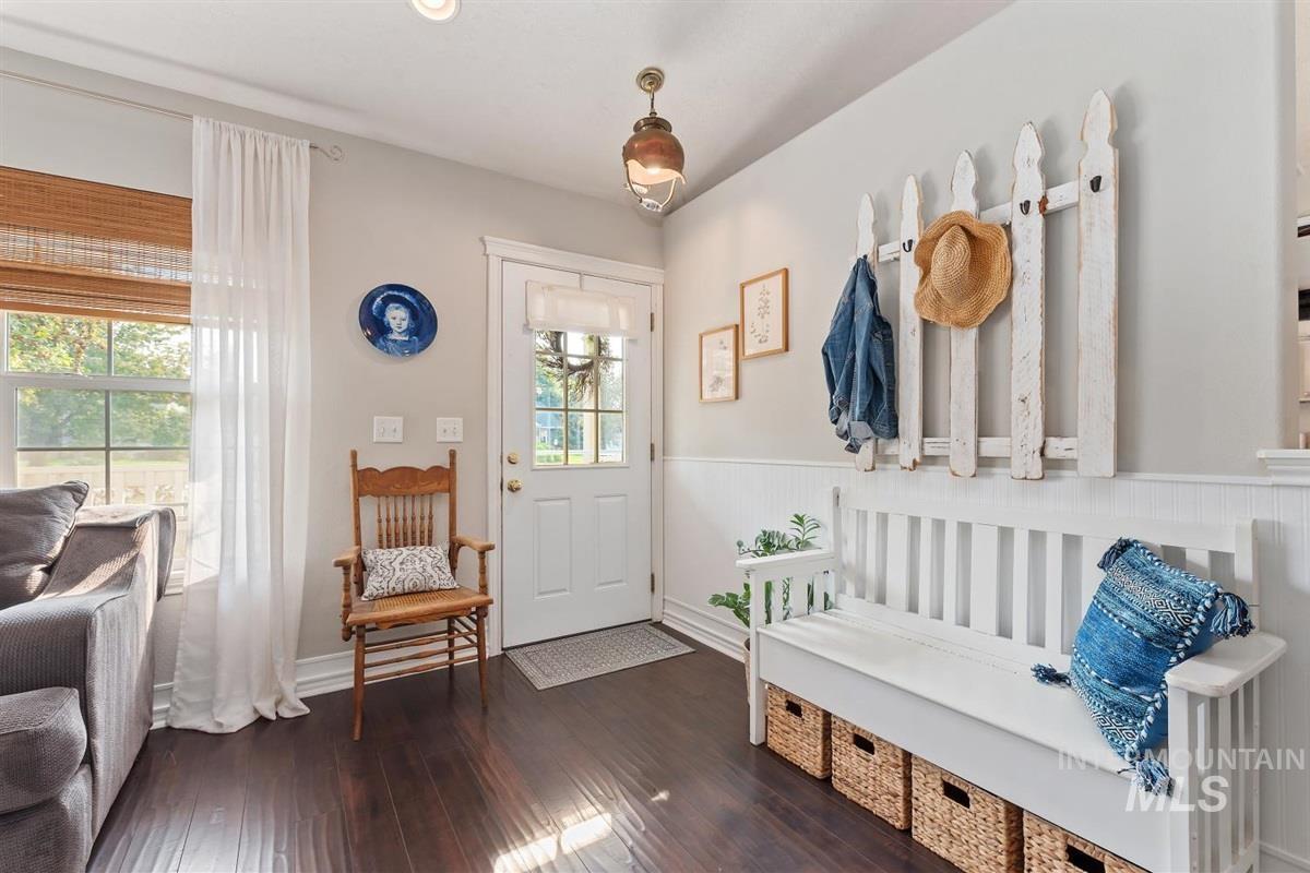 Mudroom with dark wood-type flooring and wainscoting