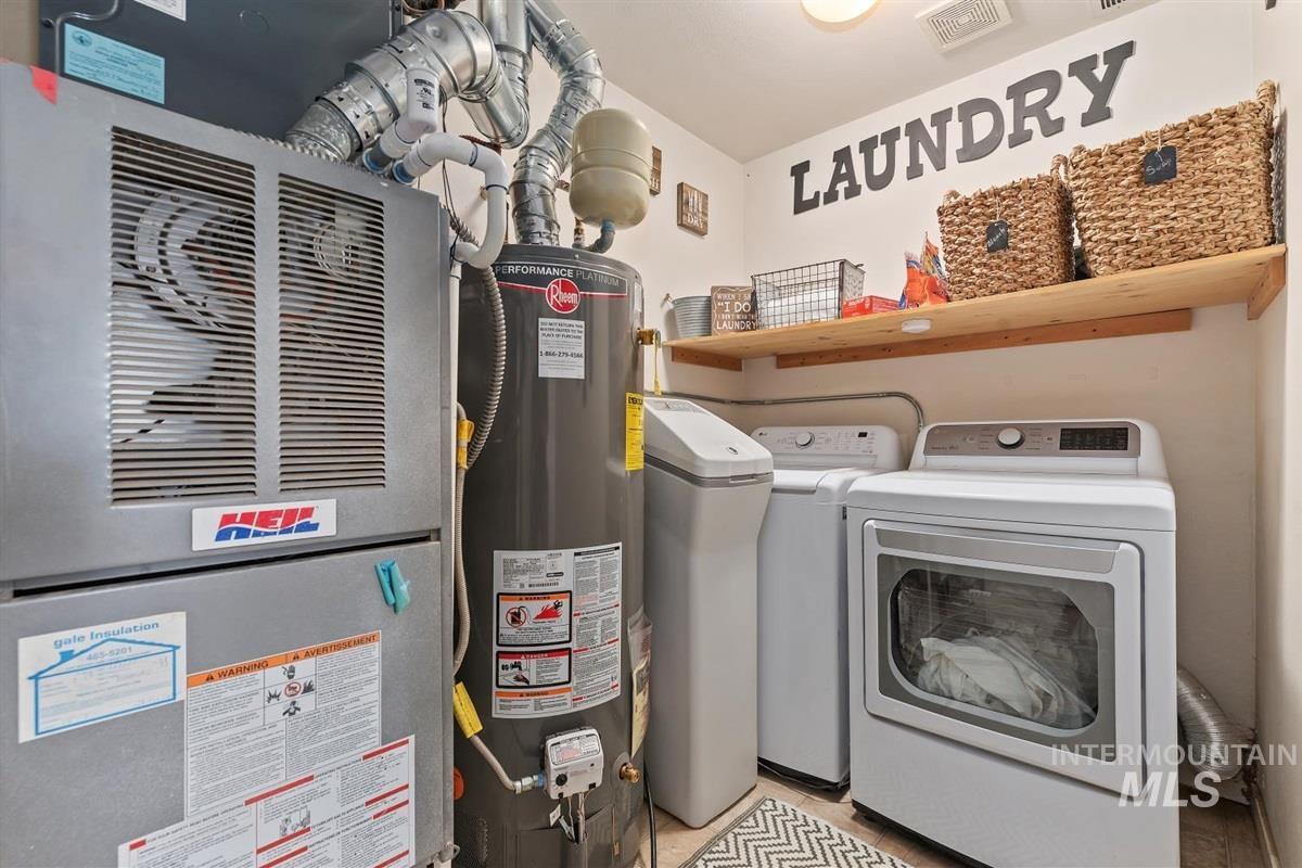 Laundry area with heating unit, water heater, and independent washer and dryer