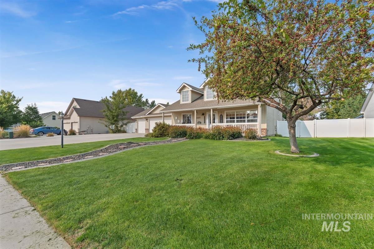 View of front of property with a porch, driveway, and a garage