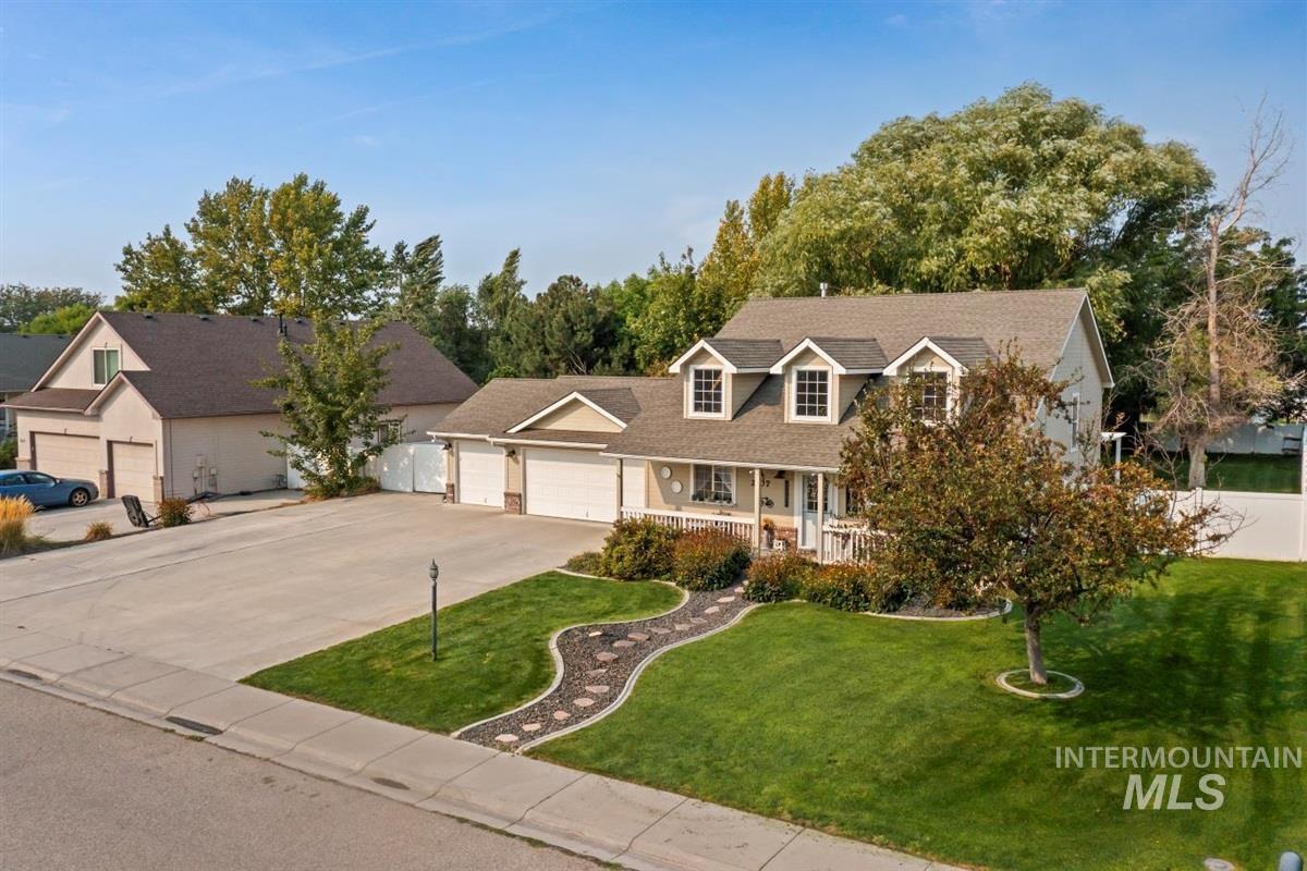 Cape cod house with a front lawn, a porch, concrete driveway, and an attached garage