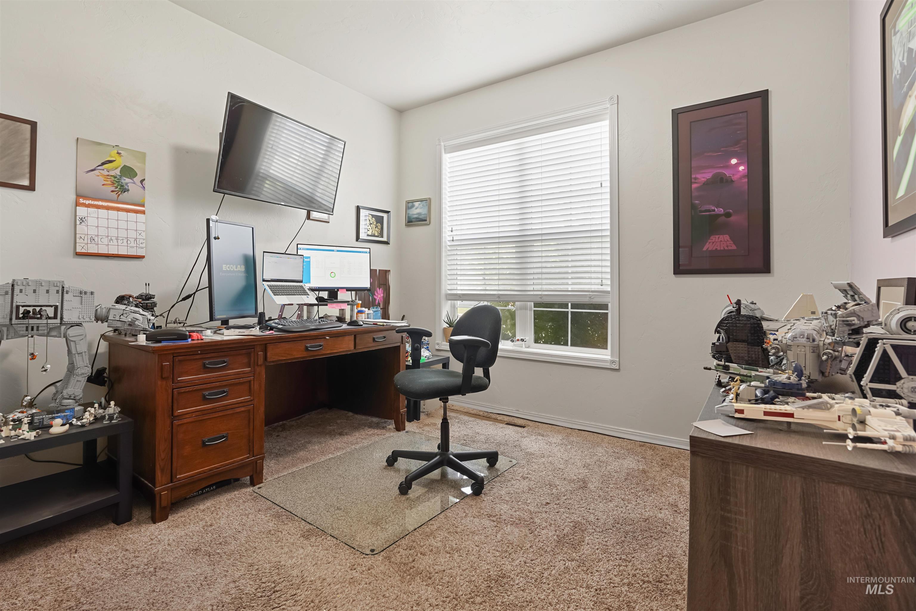 Home office with light colored carpet and baseboards