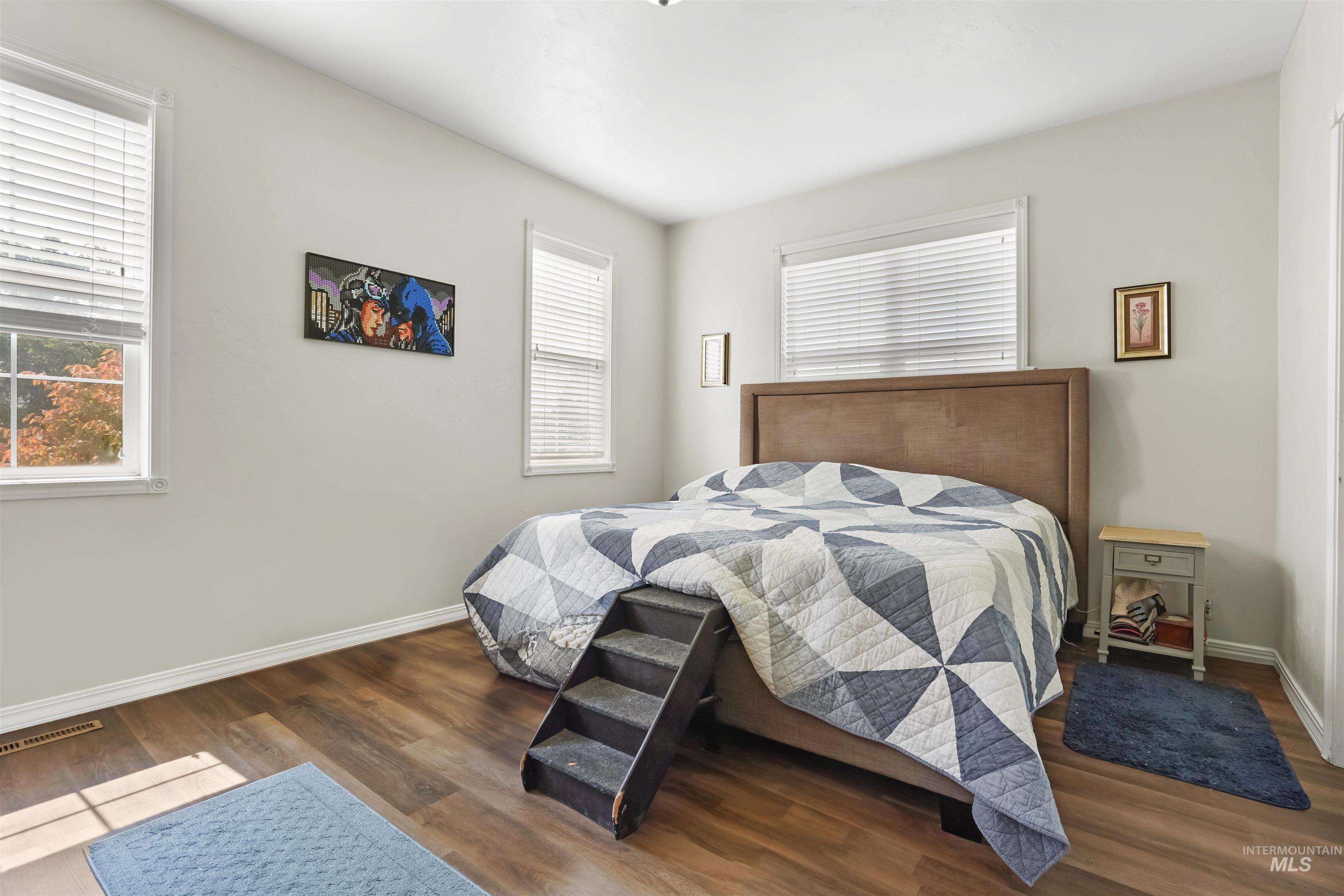 Bedroom with wood finished floors and baseboards