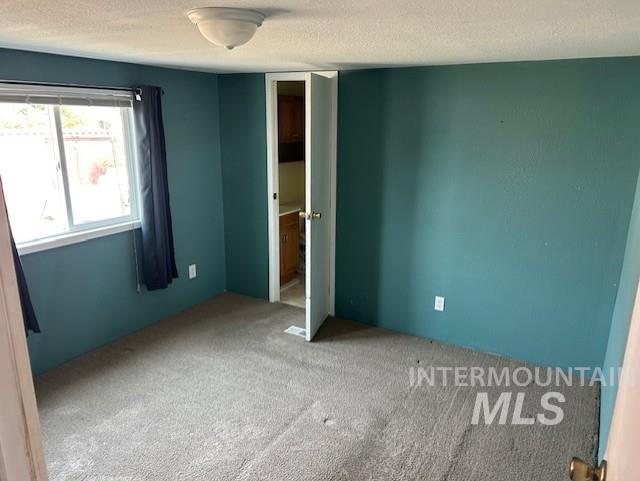 Unfurnished bedroom with carpet flooring and a textured ceiling
