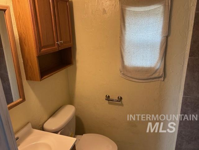 Half bath with a textured wall and vanity