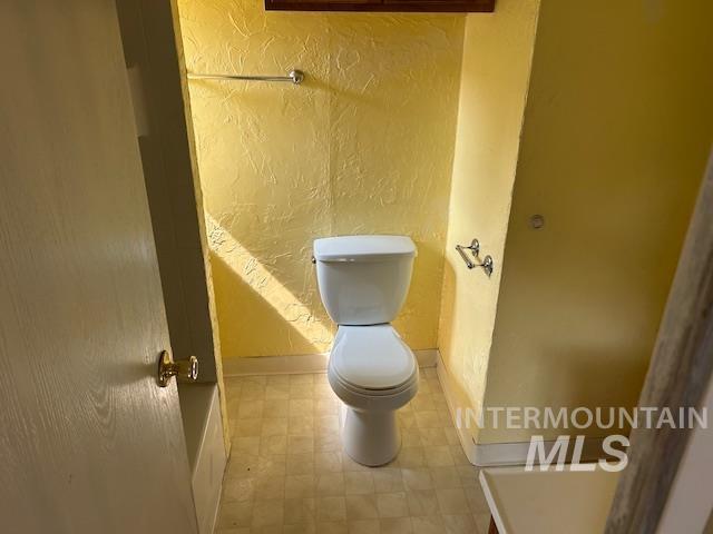 Bathroom with a textured wall and tile patterned floors