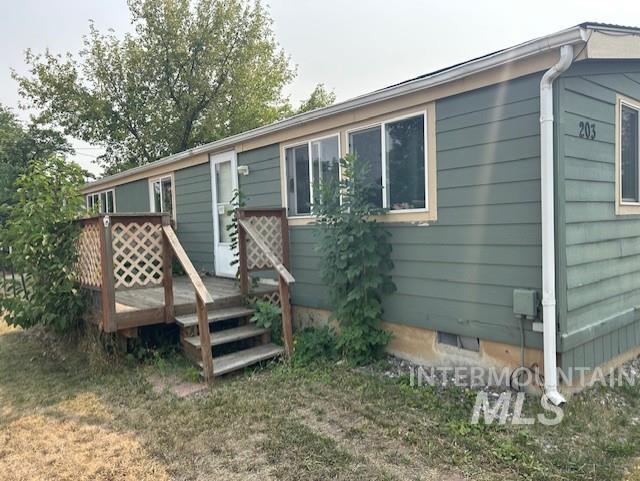 Front view of house with a wooden deck and crawl space