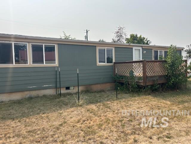 Back of house featuring a lawn, crawl space, and a deck