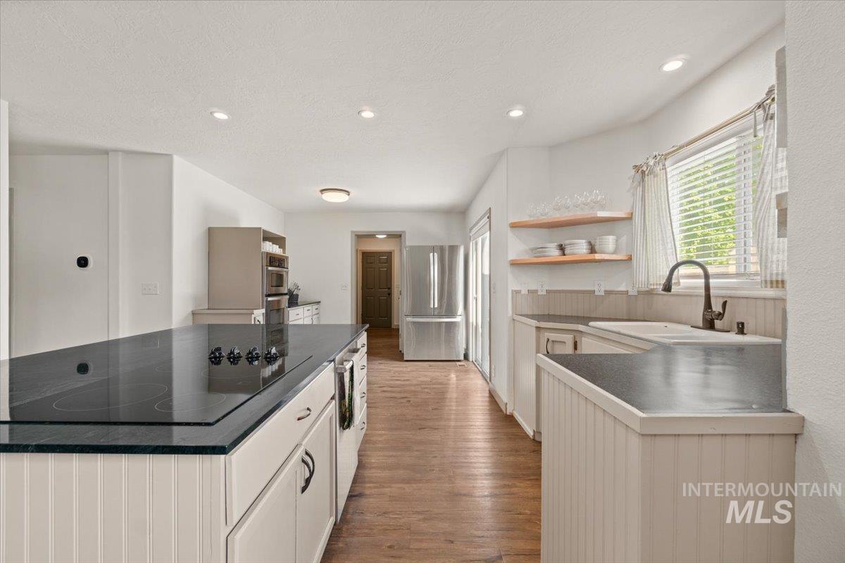 Kitchen featuring dark countertops, open shelves, stainless steel appliances, recessed lighting, and dark wood-type flooring