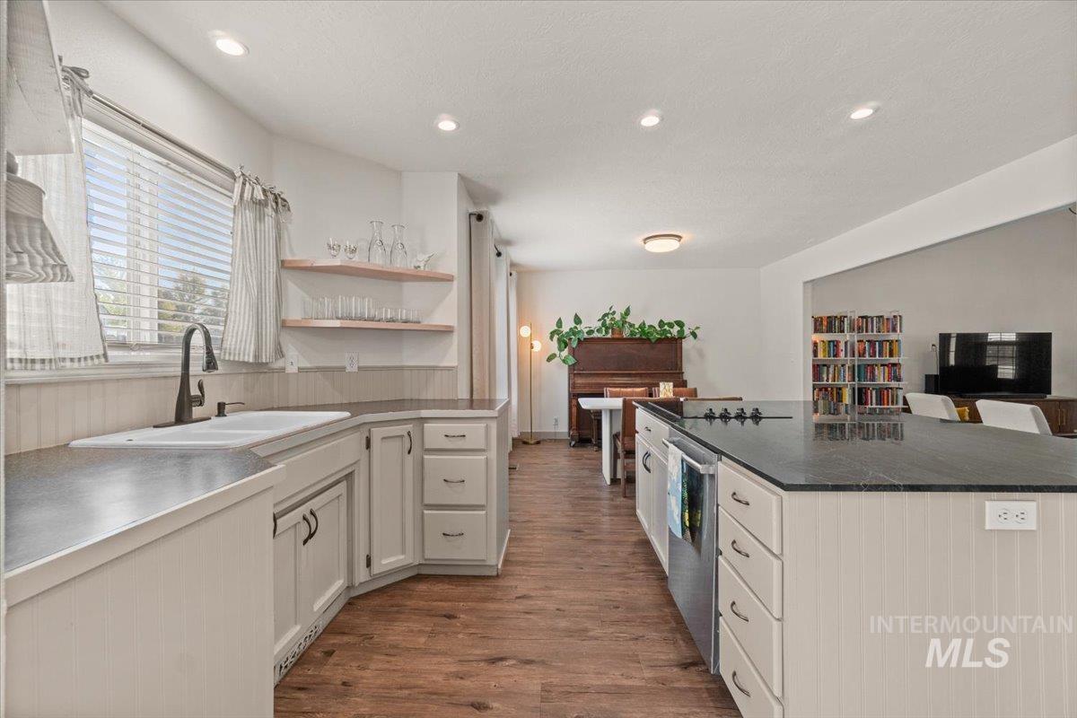 Kitchen featuring open shelves, dark wood-style flooring, recessed lighting, dishwasher, and a center island