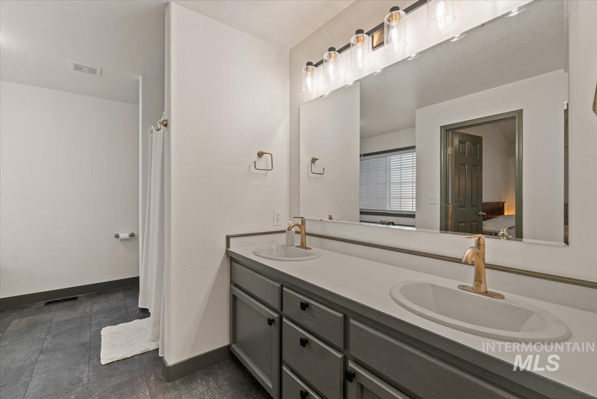 Ensuite bathroom with double vanity and baseboards