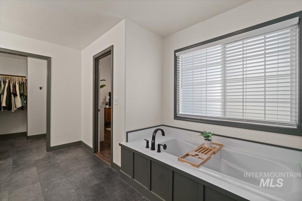 Full bath with a spacious closet and a bath