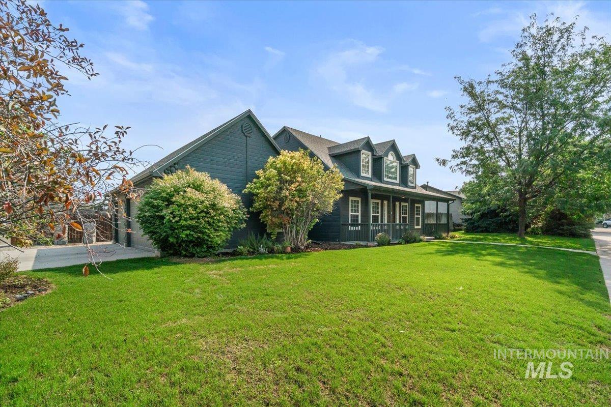 Back of property with covered porch and a lawn