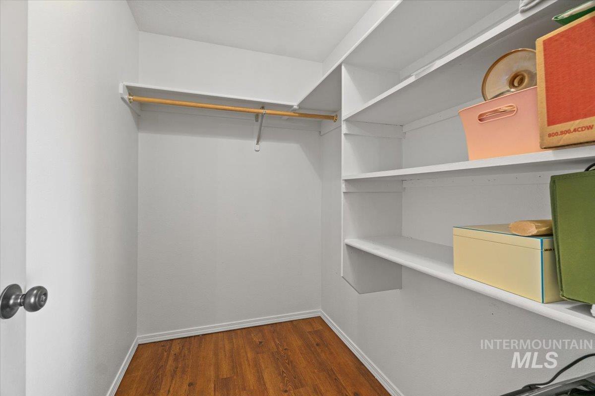 Spacious closet with dark wood-style floors