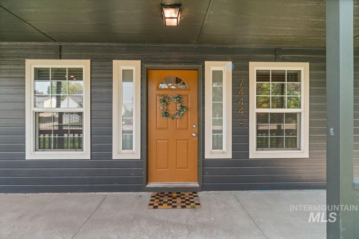 Doorway to property featuring covered porch