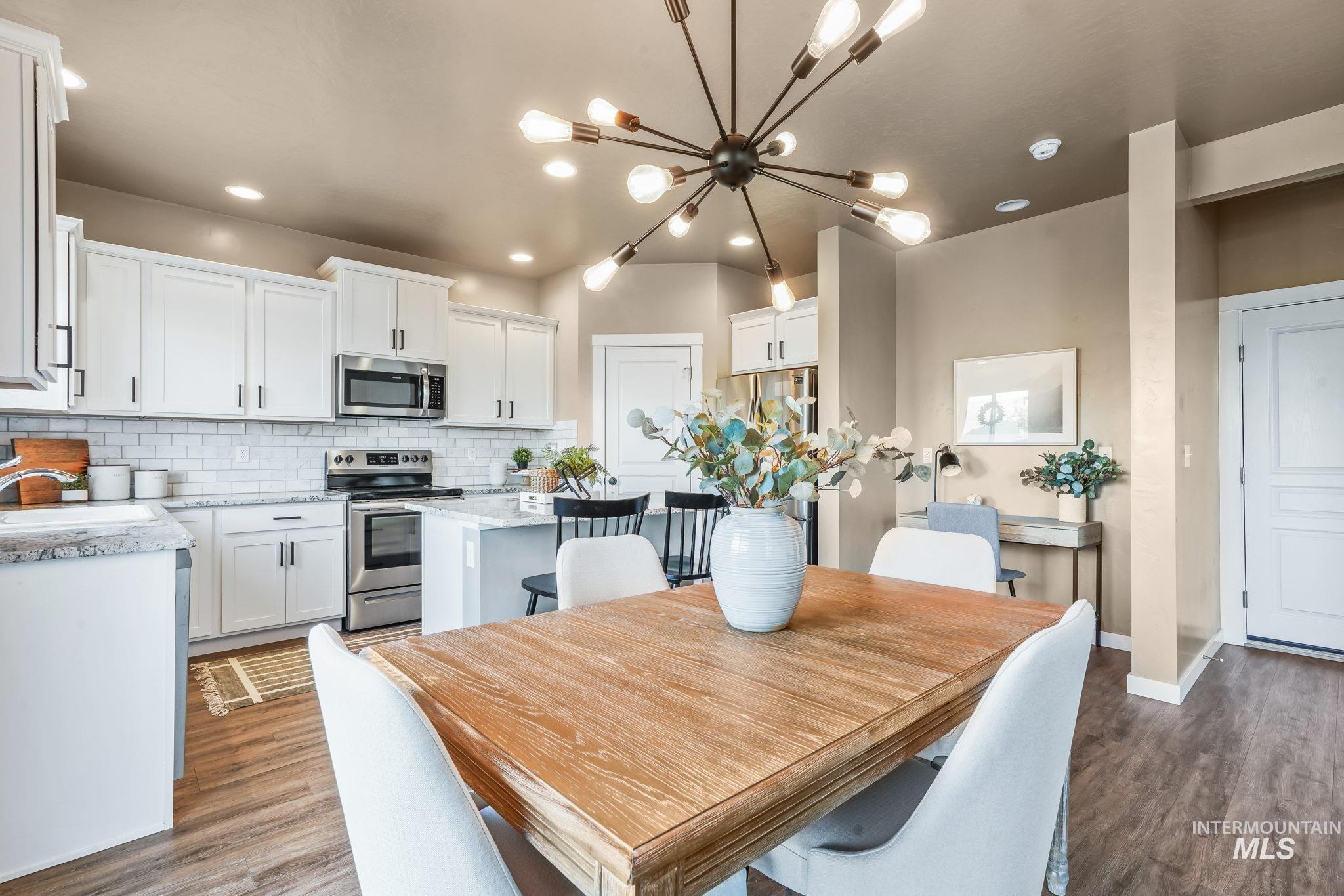Dining room with wood finished floors, a chandelier, and recessed lighting