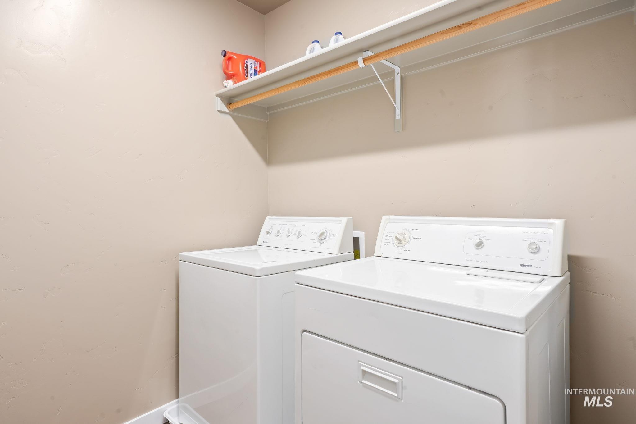 Washroom with washer and clothes dryer and baseboards
