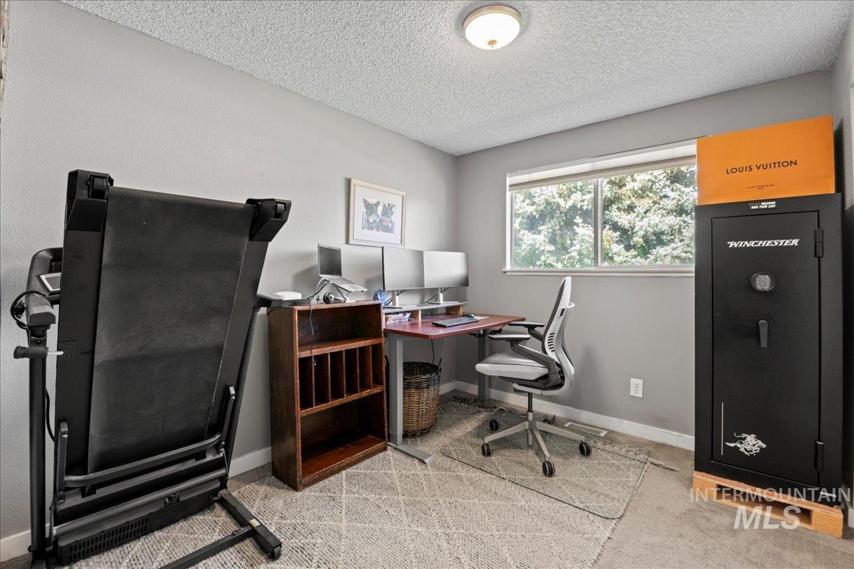 Office space with light carpet and a textured ceiling
