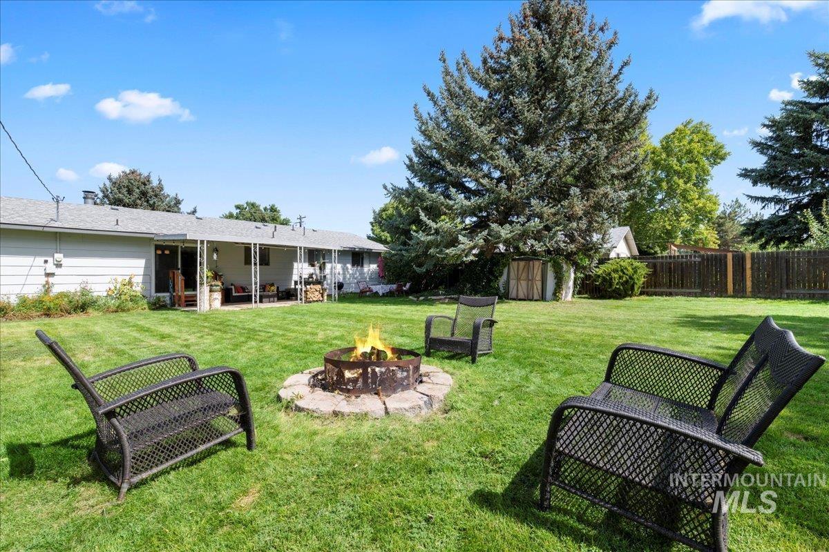 View of yard featuring a patio area, a storage unit, and an outdoor fire pit
