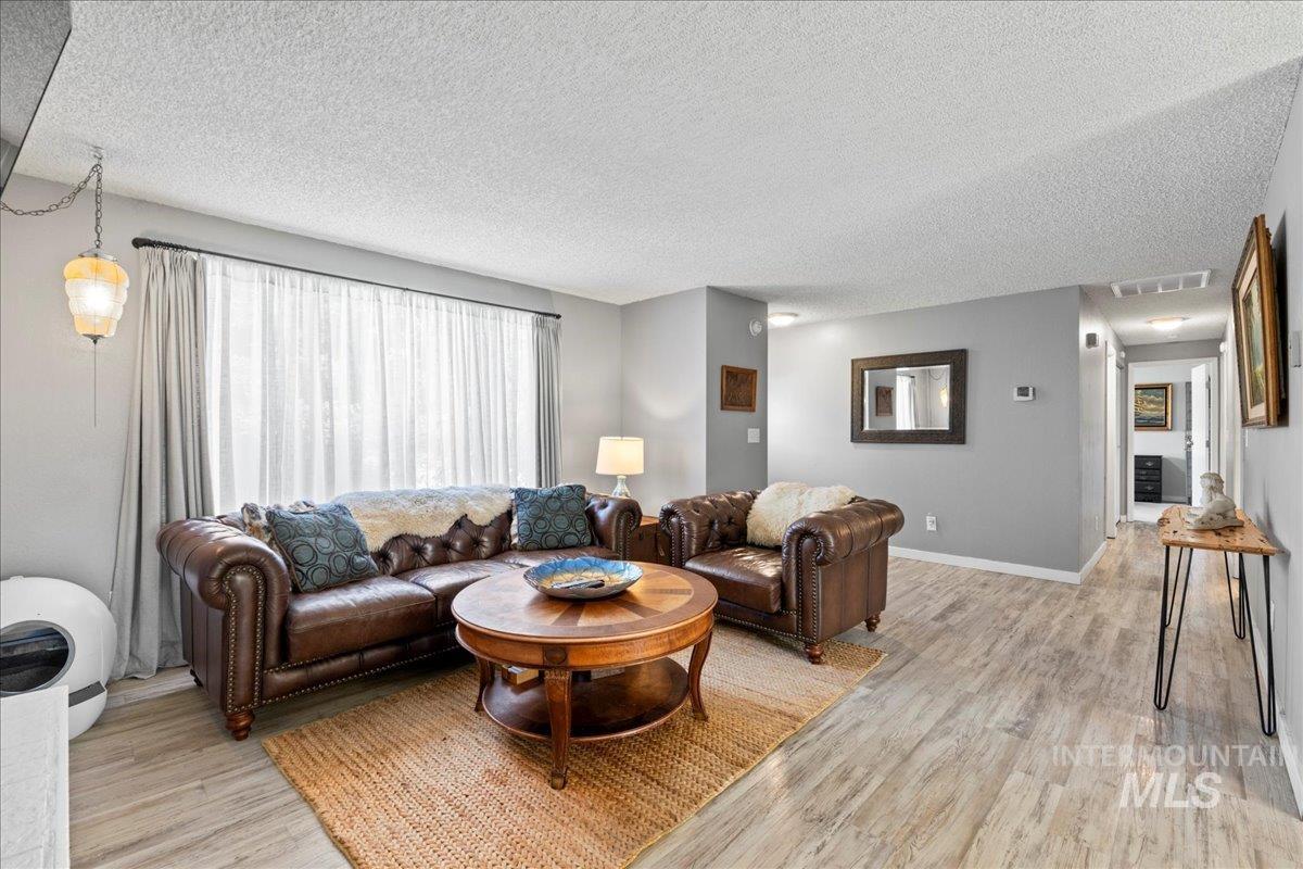 Living room with light wood-style flooring and a textured ceiling